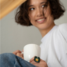 lady with a cup of lion's mane mushroom green tea from cheerful buddha