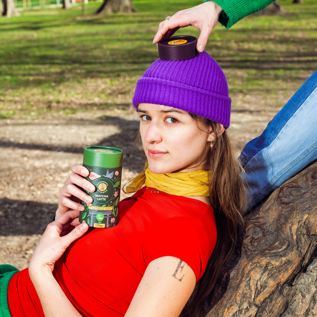 Woman in a purple hat holding a Matcha Latte tube
