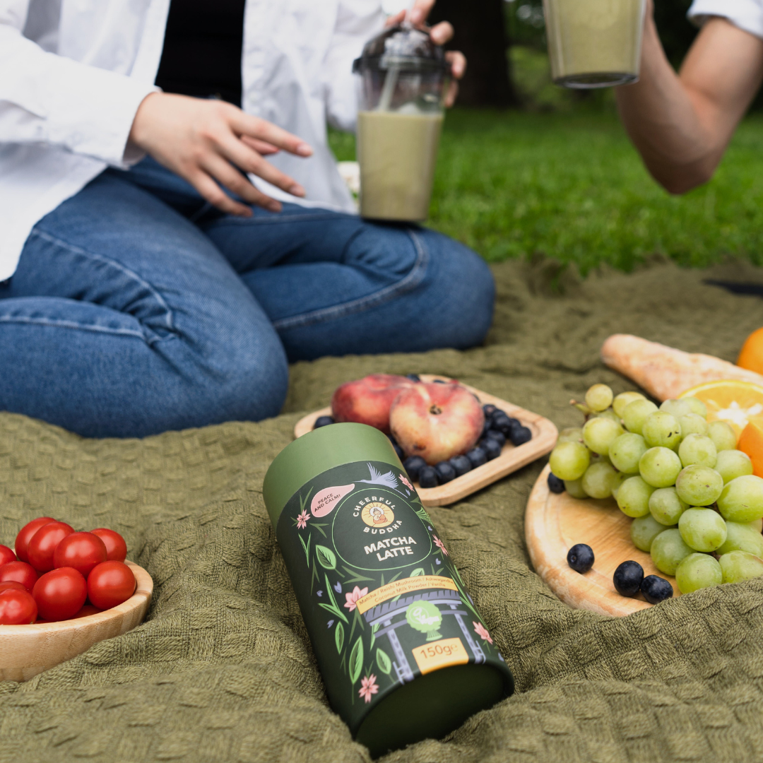 Iced matcha latte and the Matcha Latte tube on a picnic blanket
