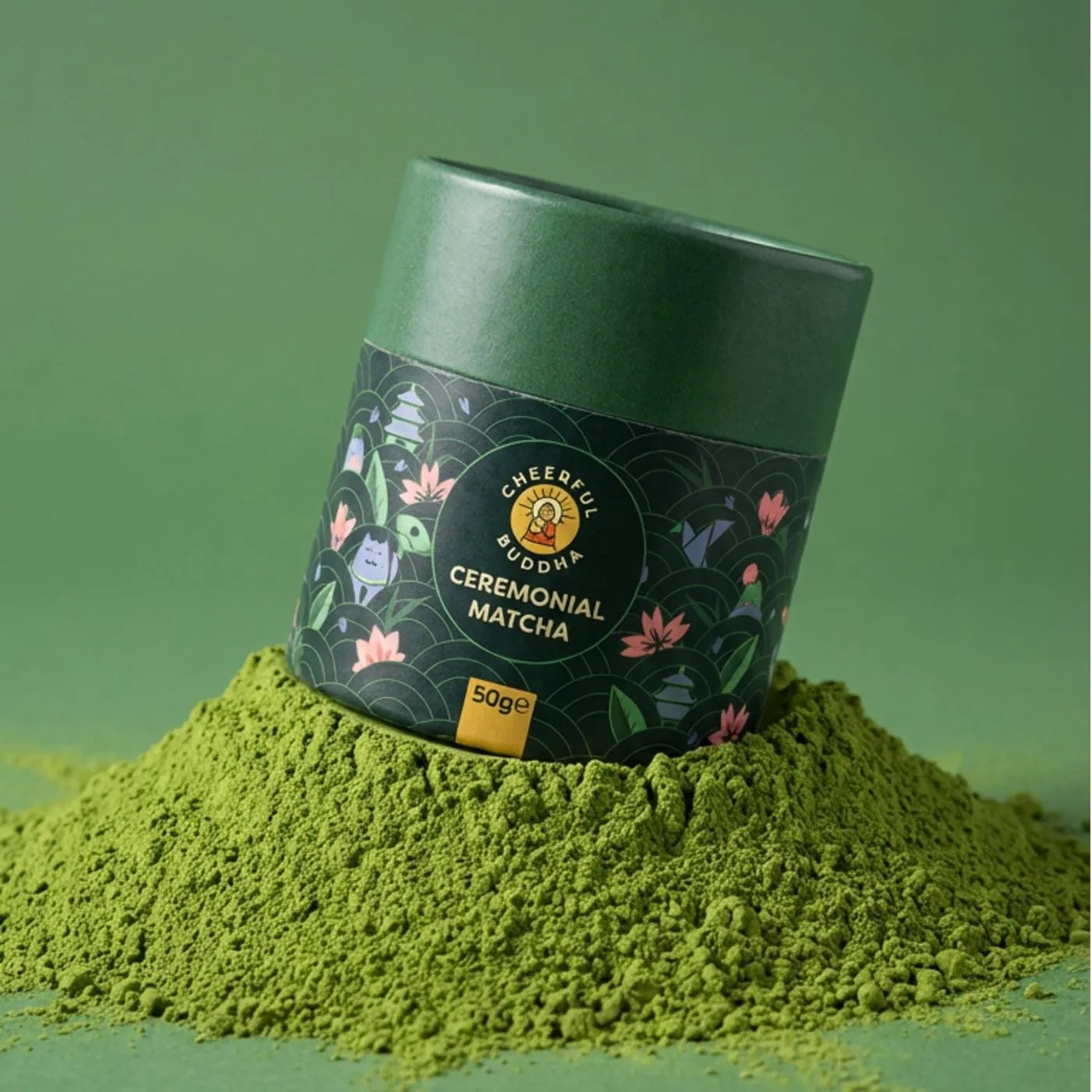Ceremonial Grade Matcha tube resting on a mound of bright green matcha powder