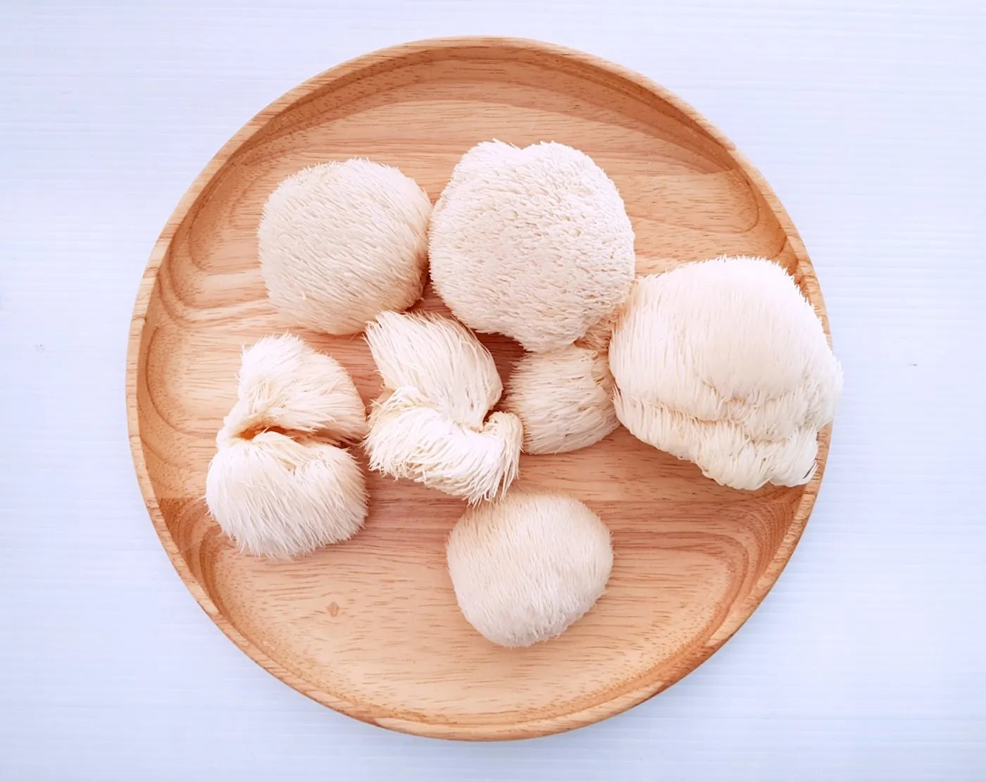 Fresh Lion's Mane mushrooms on a wooden plate